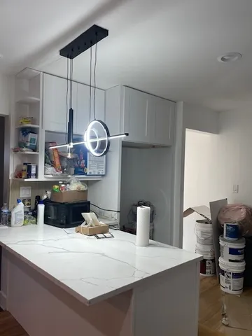 a kitchen with kitchen island a sink a stove and a wooden floors
