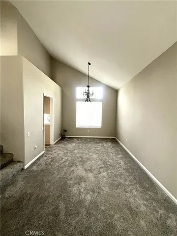 an empty room with windows & cabinet