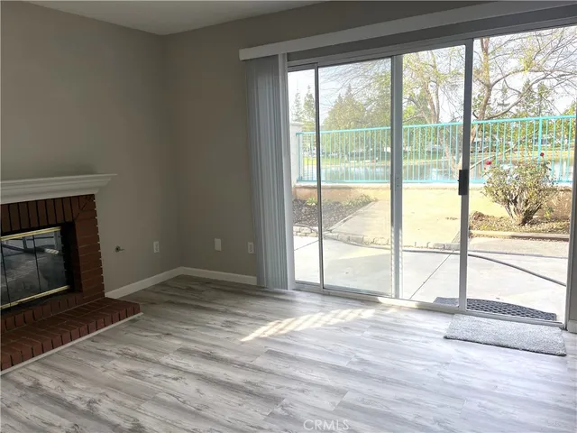 a view of empty room with wooden floor and fireplace
