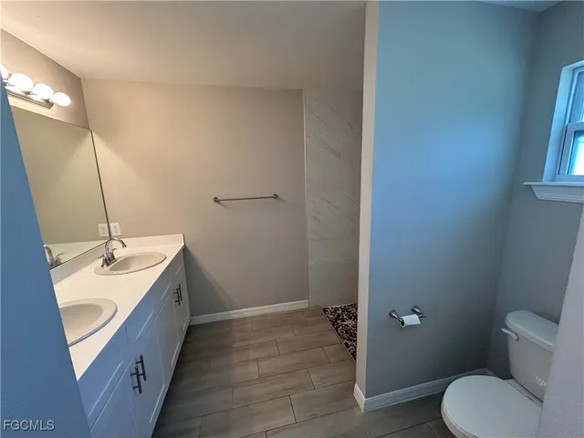 a bathroom with a sink a toilet a tub and shower