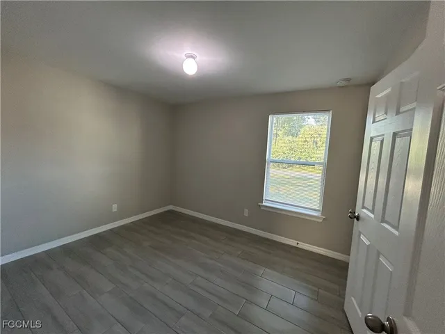 an open kitchen with white cabinets and wooden floor