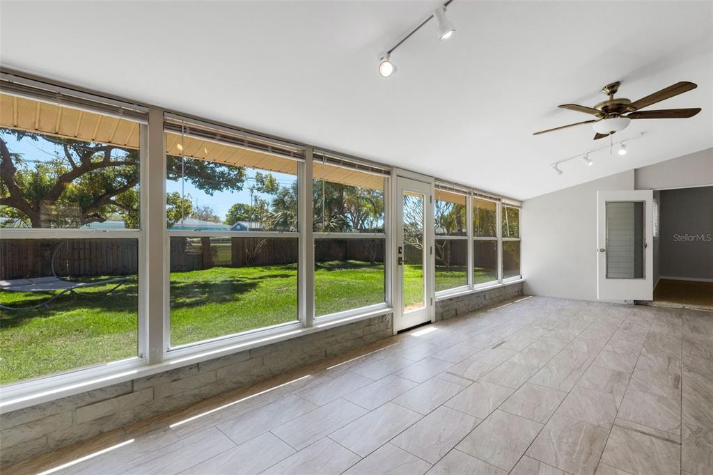 11436 Ridgewood Circle Seminole, FL 33772 - Photo 30 of 38 a view of an empty room with a fireplace and a large window with garden view