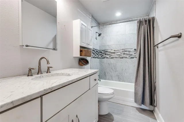 a bathroom with a granite countertop sink toilet and shower