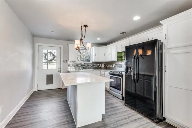an open kitchen with white cabinets and stainless steel appliances