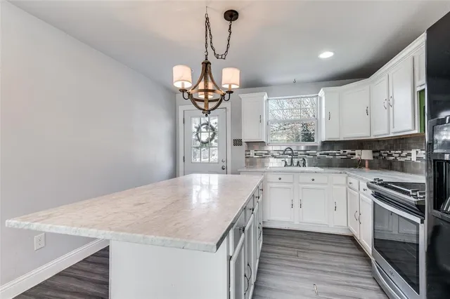a kitchen with stainless steel appliances a refrigerator and wooden floor