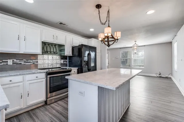 a kitchen with white cabinets stainless steel appliances and sink