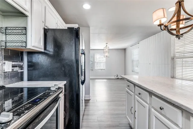 a kitchen with stainless steel appliances granite countertop a sink refrigerator and cabinets