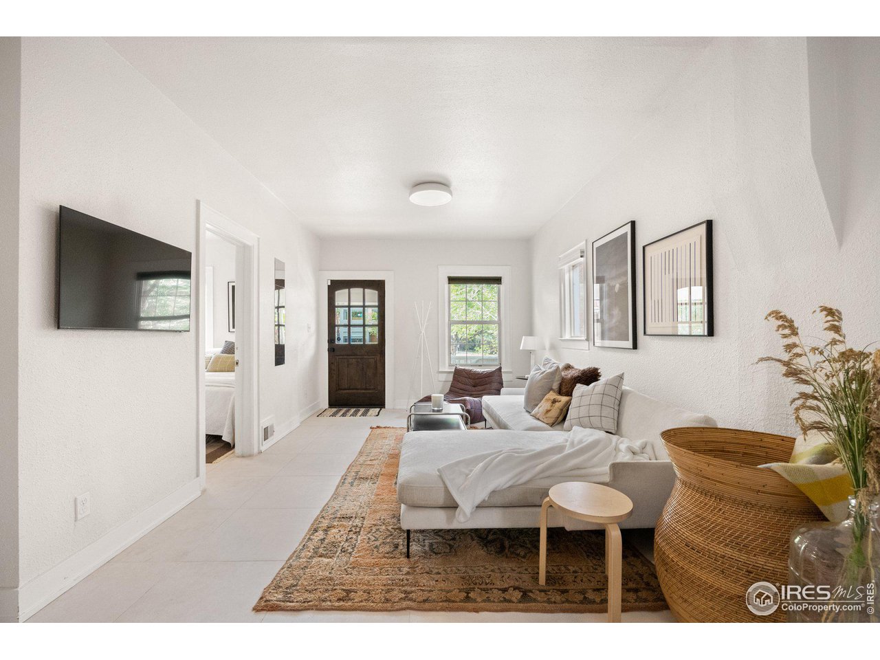 3244 Vallejo Street Denver, CO 80211 - Photo 3 of 32 a living room with furniture a rug and a flat screen tv