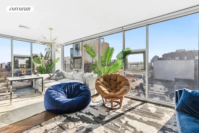 a living room with furniture a rug and a floor to ceiling window