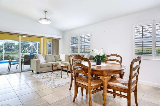 a dining room with furniture and large windows