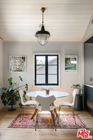 a dining room with wooden floor and a chandelier