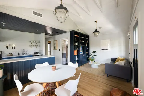 a living room with dining table and a chandelier