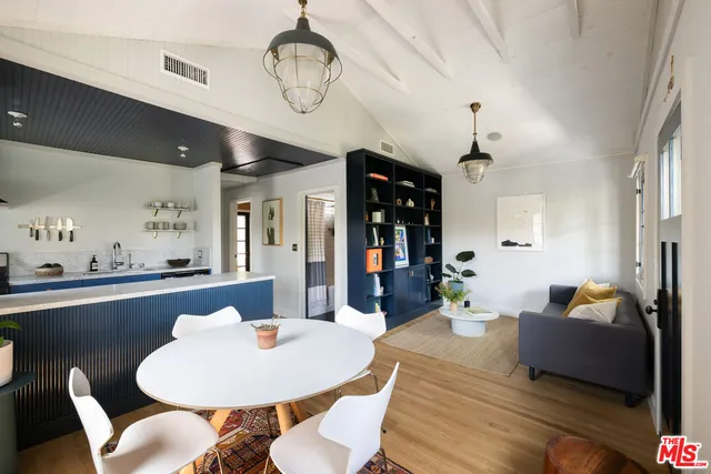 a living room with dining table and a chandelier