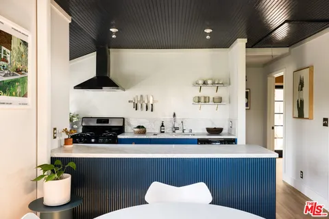 a kitchen with stainless steel appliances a microwave a stove and white cabinets