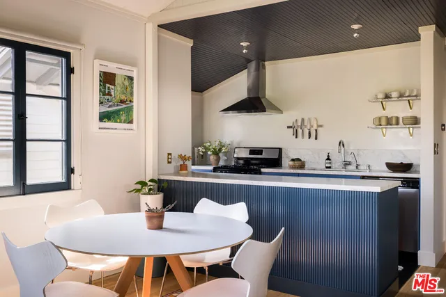 a dining room with stainless steel appliances kitchen island granite countertop a dining table and chairs