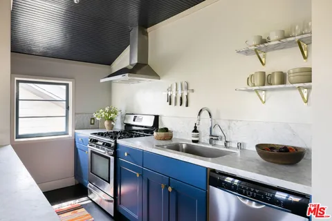 a kitchen with stainless steel appliances granite countertop a sink a stove and a wooden floors