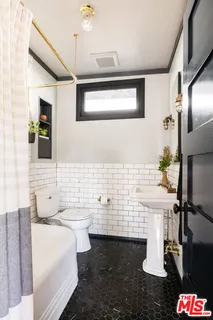 a bathroom with a sink a toilet and mirror