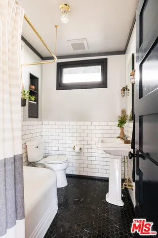 a bathroom with a sink a toilet and mirror
