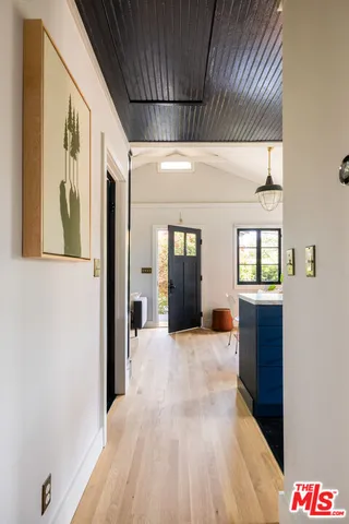 a view of hallway with wooden floor and cabinet