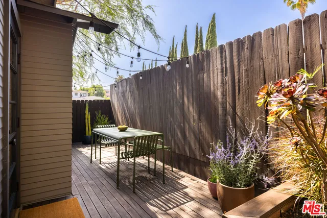 a view of backyard with a table and chairs and a potted plant