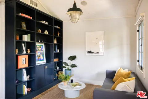 a living room with furniture and a book shelf