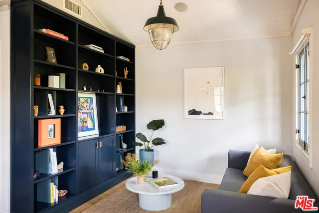 a living room with furniture and a book shelf