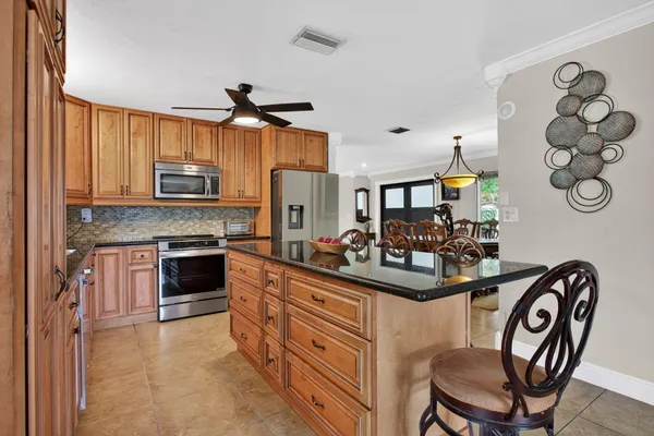 a kitchen with stainless steel appliances granite countertop a stove a sink dishwasher and a refrigerator with wooden floor