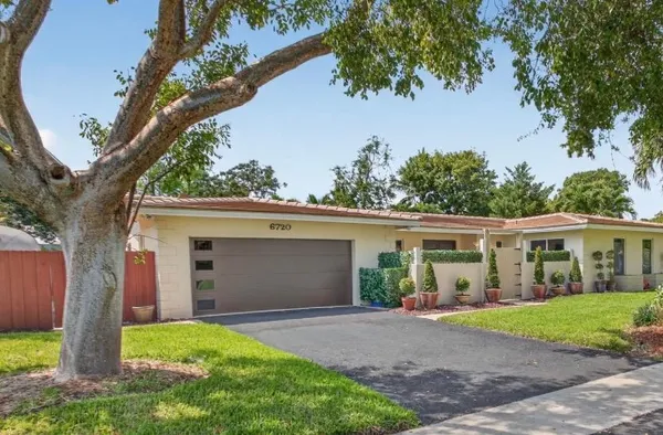 front view of a house with a yard and an trees