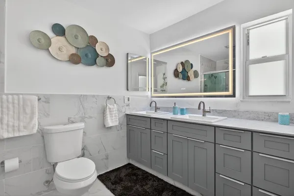 a bathroom with a sink a toilet and a mirror