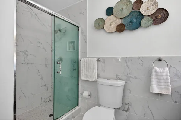 a white toilet sitting next to a bathroom sink and vanity