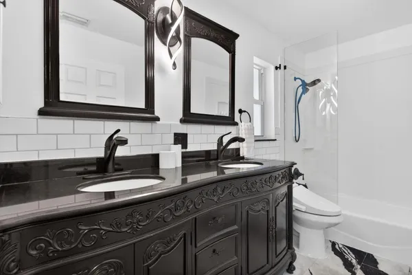 a bathroom with a granite countertop sink a toilet and mirror