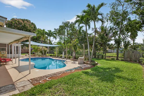 a view of backyard with swimming pool and patio