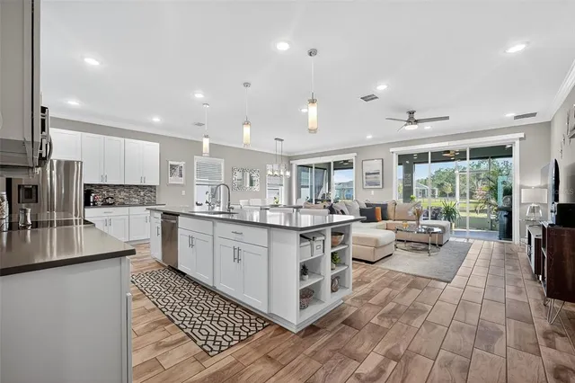 a kitchen with sink a counter top space and living room view