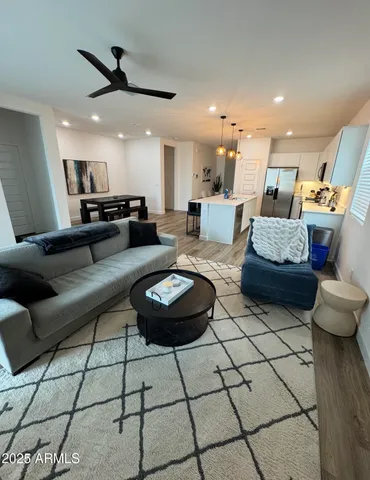 a living room with furniture and a view of kitchen