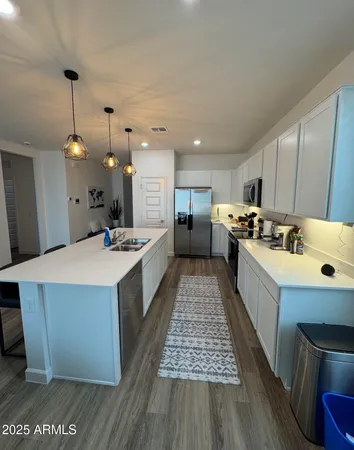 a large kitchen with kitchen island a sink stainless steel appliances and cabinets