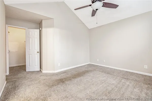 an empty room with fan and windows