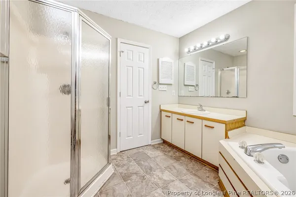 a bathroom with a tub sink and mirror
