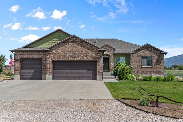 5702 950 North Ogden, UT 84404 - Photo 1 of 36 Brick and stucco exterior featuring an attached triple-car garage with individual doors