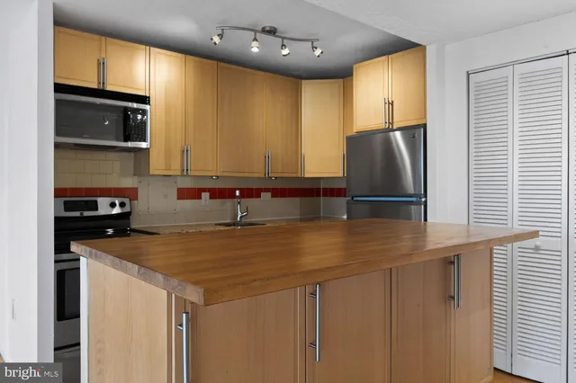 a kitchen with granite countertop a stove top oven microwave and cabinets