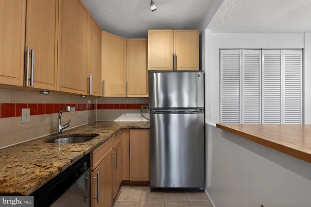 a kitchen with stainless steel appliances a refrigerator and a stove