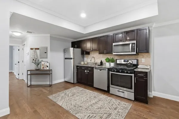 a kitchen with granite countertop wooden cabinets and stainless steel appliances