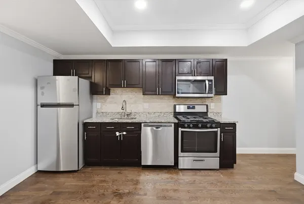 a kitchen with stainless steel appliances granite countertop a stove a refrigerator and a microwave