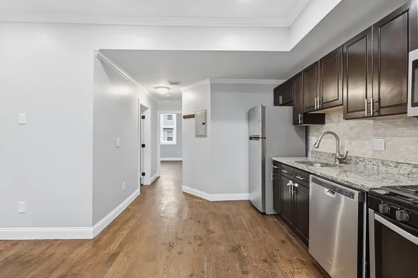 a kitchen with stainless steel appliances granite countertop a refrigerator and a sink