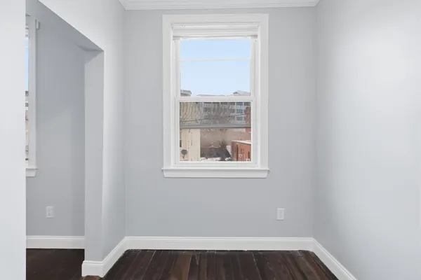 a view of small space with wooden floor and a window