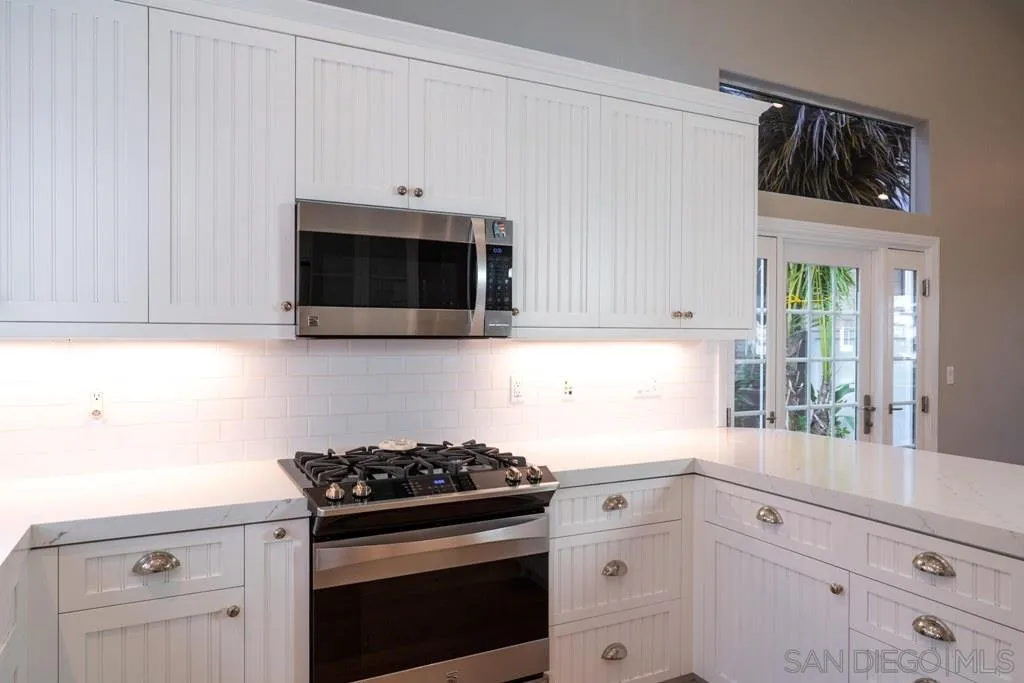 8 Racing Wind Irvine, CA 92614 - Photo 6 of 25 a kitchen with white cabinets and stainless steel appliances