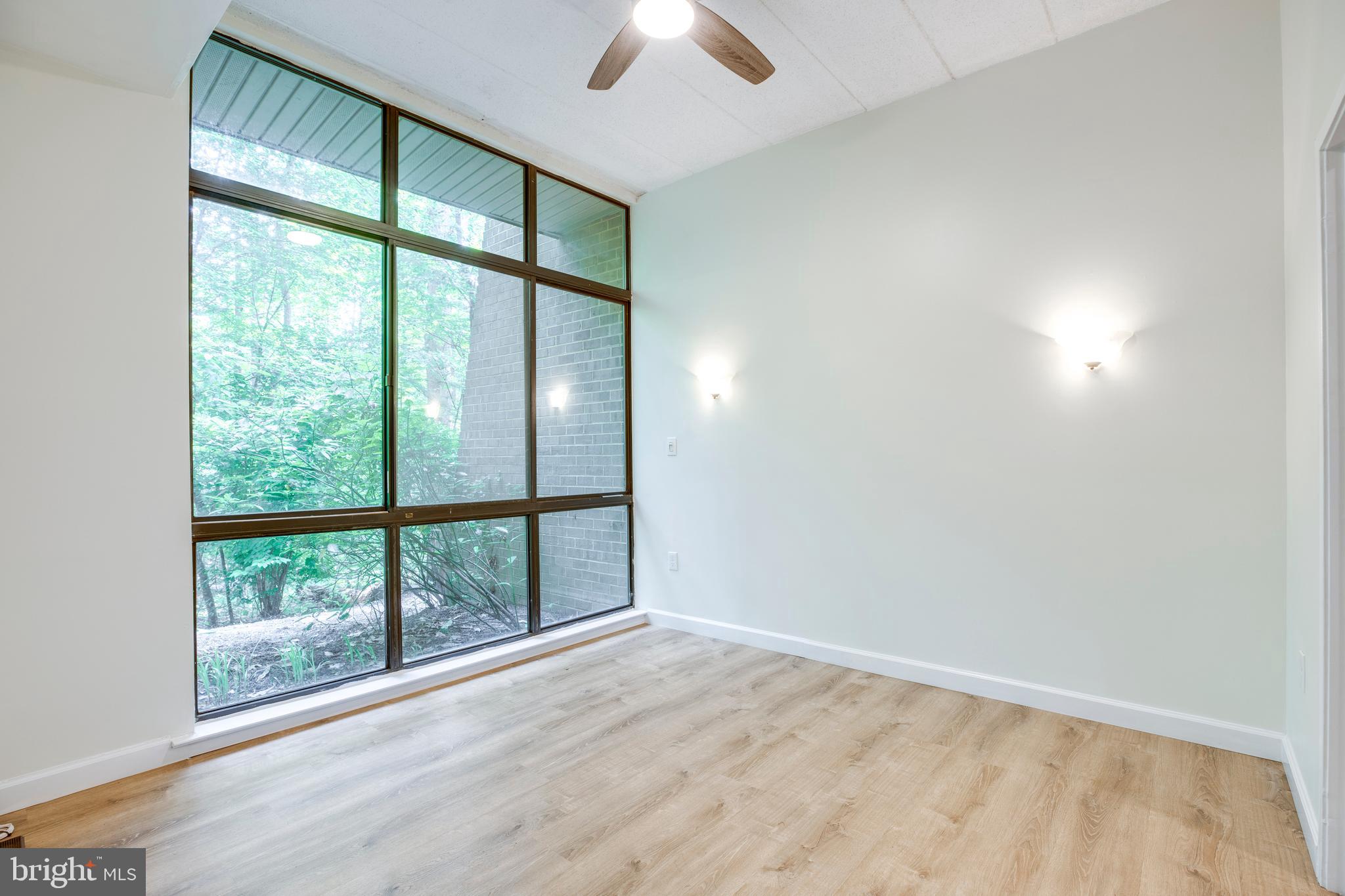 2106 Green Watch Way, Unit 101 Reston, VA 20191 - Photo 14 of 40 an empty room with chandelier fan and windows