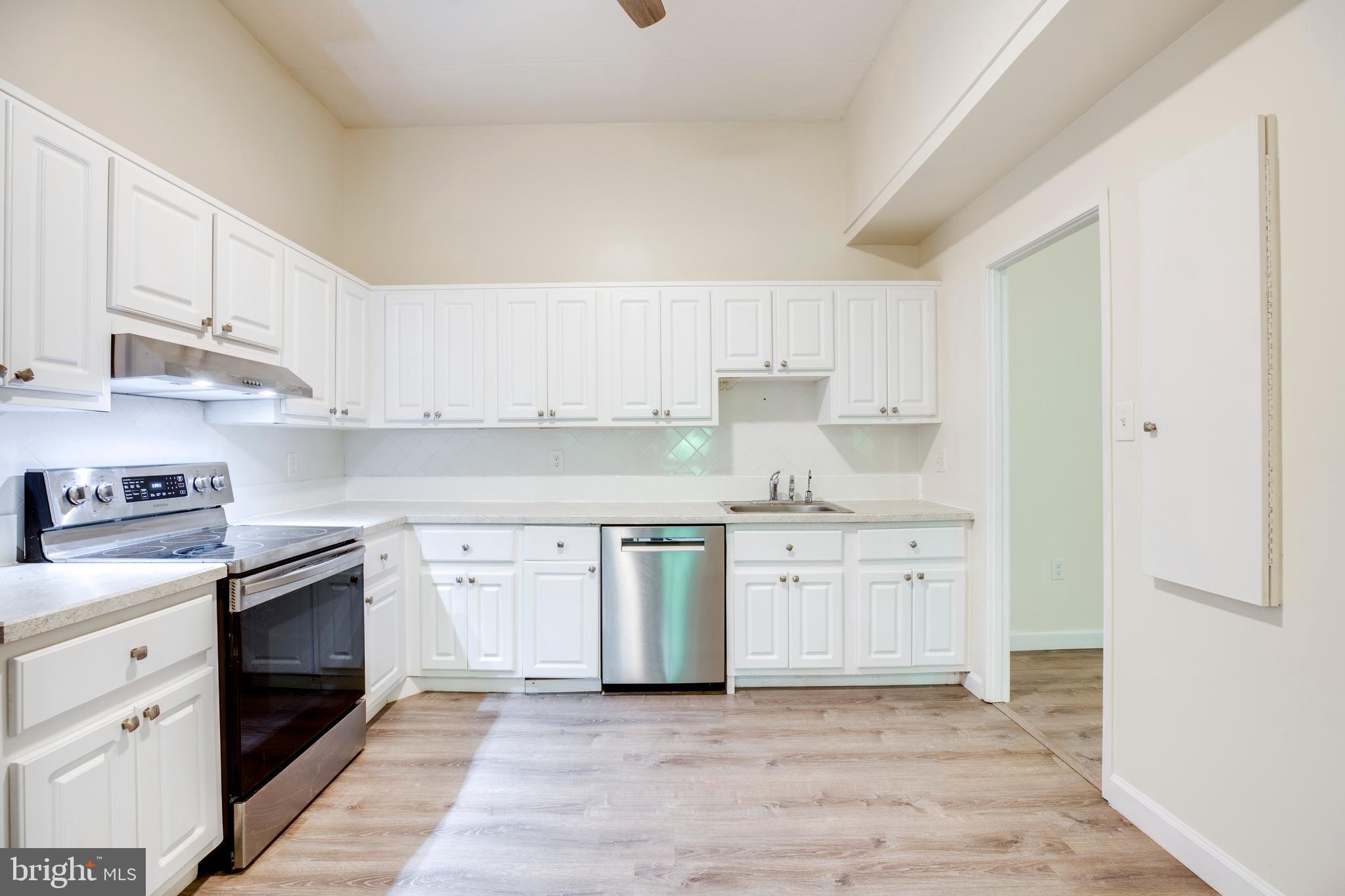 2106 Green Watch Way, Unit 101 Reston, VA 20191 - Photo 15 of 40 a kitchen with granite countertop white cabinets and white appliances
