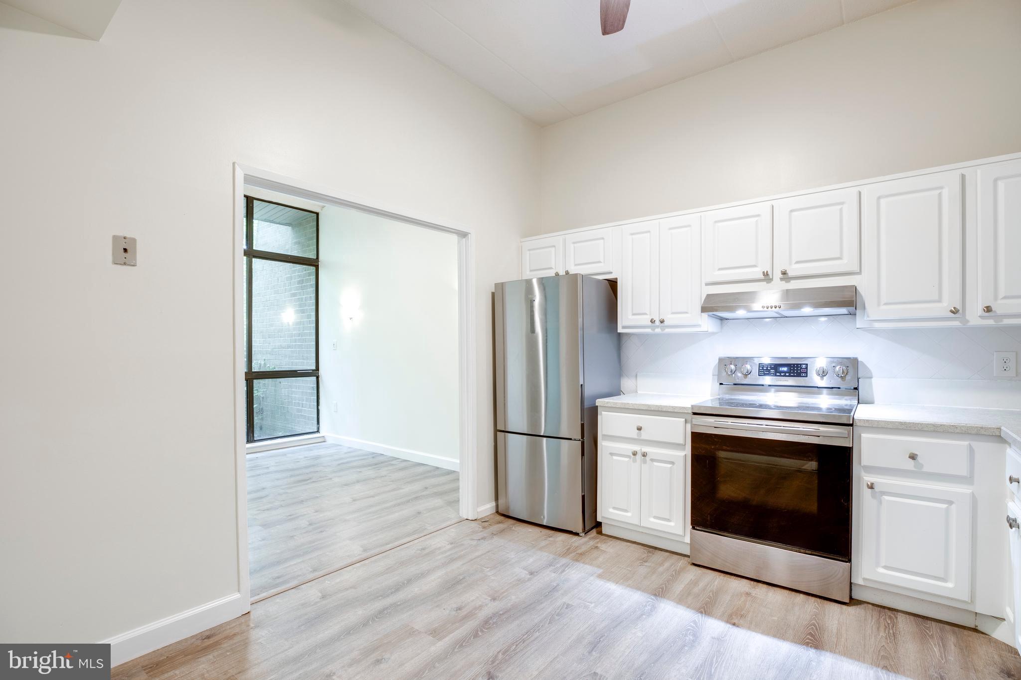 2106 Green Watch Way, Unit 101 Reston, VA 20191 - Photo 17 of 40 a kitchen with stainless steel appliances granite countertop a refrigerator and a stove top oven