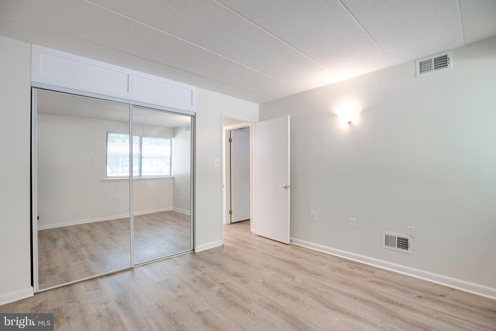 2106 Green Watch Way, Unit 101 Reston, VA 20191 - Photo 26 of 40 an empty room with wooden floor and windows