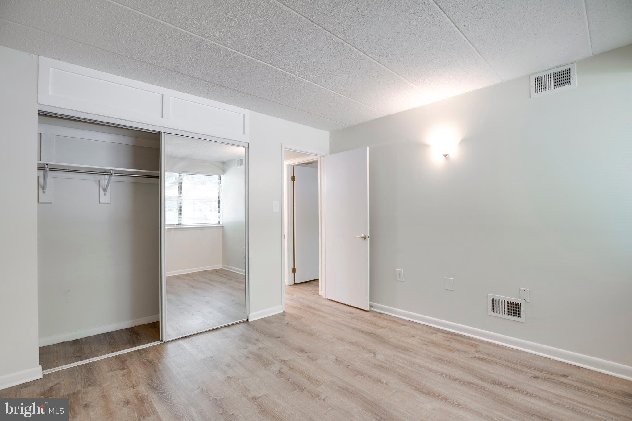 2106 Green Watch Way, Unit 101 Reston, VA 20191 - Photo 27 of 40 an empty room with wooden floor & windows cabinet